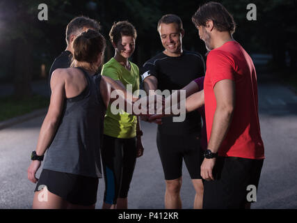 Gruppe von gesunden Läufer, fünf auf einander beim Erfolg feiern nach dem Training. Stockfoto