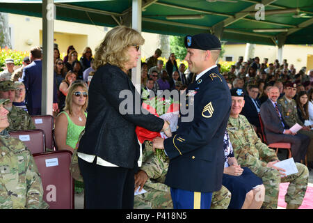 Frau Erin Williams, Frau des scheidenden US-Armee Afrika und Südlichen europäischen Task Force Commander Generalmajor Darryl A. Williams, erhält rote Rosen von Staff Sgt. Jeremia Steele, während der USARAF/SETAF Ändern des Befehls Zeremonie, 1. Juni 2016 in der Caserma Ederle, Vicenza, Italien. (U.S. Armee Foto von visuellen Informationen Spezialist Paolo Bovo/freigegeben) Stockfoto