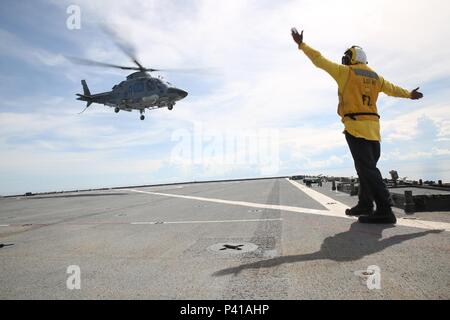 SULU SEE (5. Juni 2016) - boatswains Mate 2. Klasse Lonnie Sylvester, ein Seemann, der an Bord der Vorwärts - bereitgestellt Whidbey Island Klasse dock Landung Schiff USS Ashland (LSD 48), führt eine philippinische Hubschrauber während der Durchführung deck Landung Qualifikationen zur Unterstützung der Übung die Zusammenarbeit flott Bereitschaft und Weiterbildung. CARAT ist eine Reihe von jährlichen, bilaterale Seeverkehrsabkommen zwischen der US Navy, US Marine Corps und der bewaffneten Kräfte der neun Partner Nationen Bangladesch, Brunei, Kambodscha, Indonesien, Malaysia, Singapur, den Philippinen, Thailand, Timor-Leste. Die Ashland ist mit dem zugeordneten Stockfoto