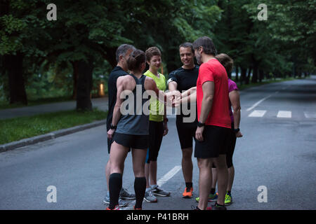 Gruppe von gesunden Läufer, fünf auf einander beim Erfolg feiern nach dem Training. Stockfoto