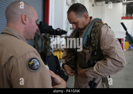 Major Jonathan Geisler, eine AH-1Z Viper Cobra Kampfhubschrauber Pilot mit Marine Light Attack Helicopter Training Squadron 303, Marine Flugzeuge Gruppe 39, 3. Marine Flugzeugflügel, beauftragt Generalmajor Daniel O'Donohue, der 1. Marine Division kommandierender General, wie sein Flug Weste vor dem Fliegen in einem AH-1Z Hubschrauber an Bord der Marine Corps Air Station Camp Pendleton, Calif., 2. Juni 2016 einzustellen. Der Flug war im Laufe der Ausbildung Bereiche an Bord Marine Corps Base Camp Pendleton, Kalifornien durchgeführt, in einer Demonstration der Technologie und der Funktionen des AH-1Z Viper Cobra Kampfhubschrauber. Stockfoto