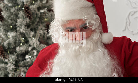 Santa Claus in Brillen lustige Gesichter ziehen und Lachen Stockfoto