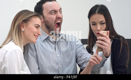 Junge Büro Mitarbeiter Spaß unter selfies am Telefon Stockfoto