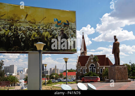 Statue von Sam Nujoma, dem ersten Präsidenten von Namibia, steht von einer revolutionären themed Billboard mit Christus Kirche im Hintergrund, Windhoek, Namibia. Stockfoto