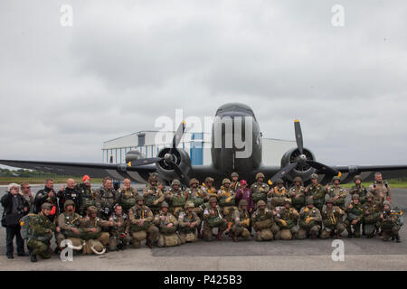 Mitgliedern des runden Vordach Fallschirmspringen Team und Fallschirmjäger aus der Luftlandebrigade 1 posieren für ein Foto vor Fallschirmspringen in Fresville, Frankreich, 2. Juni 2016. Die runde Vordach Fallschirmspringen Team führt den Zweiten Weltkrieg Stil fallschirmspringen Tätigkeiten der Speicher der Fallschirmjäger, die kämpften, Europa und ihren selbstlosen Opfer zu befreien zu verstärken. (U.S. Armee Foto von SPC. Joseph Cathey/Freigegeben) Stockfoto