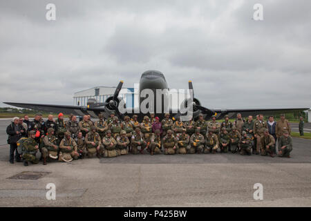 Mitgliedern des runden Vordach Fallschirmspringen Team und Fallschirmjäger aus der Luftlandebrigade 1 posieren für ein Foto vor Fallschirmspringen in Fresville, Frankreich, 2. Juni 2016. Die runde Vordach Fallschirmspringen Team führt den Zweiten Weltkrieg Stil fallschirmspringen Tätigkeiten der Speicher der Fallschirmjäger, die kämpften, Europa und ihren selbstlosen Opfer zu befreien zu verstärken. (U.S. Armee Foto von SPC. Joseph Cathey/Freigegeben) Stockfoto