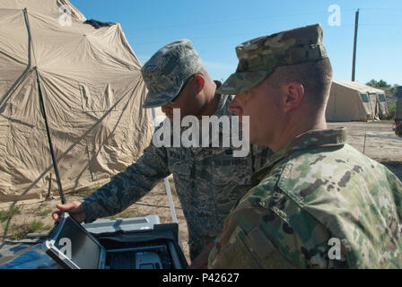 Master Sgt. Aaron Z McKenzie, 225 Air Control Squadron, ein Element der Oregon National Guard, Funksender, erklärt Sgt. Shawn Keeton, 102 d Public Affairs Loslösung, Sender, wie Frequenzen, um Nachrichten für die zugewiesenen Aufgaben übertragen, während die Multi - Echelon integrierte Feuerwehr Ausbildung (MiBT) Übung Juni 7, 2016, in Fort Hood, Texas. Ein MiBT ist ein Mehrkomponenten Schulungsveranstaltung der Bereitschaft der Reserve und aktive Komponenten in Übereinstimmung mit Insgesamt tritt die Politik der US-Armee. (Mississippi National Guard Foto von Sgt. DeUndra Braun, 102 d Pub Stockfoto