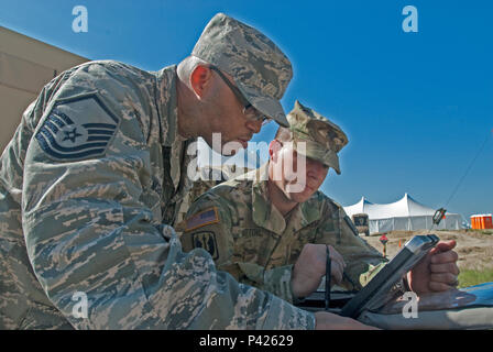 Master Sgt. Aaron Z McKenzie, 225 Air Control Squadron, ein Element der Oregon National Guard, Funksender, erklärt Sgt. Shawn Keeton, 102 d Public Affairs Loslösung, Sender, wie Frequenzen, um Nachrichten für die zugewiesenen Aufgaben übertragen, während die Multi - Echelon integrierte Feuerwehr Ausbildung (MiBT) Übung Juni 7, 2016, in Fort Hood, Texas. Ein MiBT ist ein Mehrkomponenten Schulungsveranstaltung der Bereitschaft der Reserve und aktive Komponenten in Übereinstimmung mit Insgesamt tritt die Politik der US-Armee. (Mississippi National Guard Foto von Sgt. DeUndra Braun, 102 d Pub Stockfoto