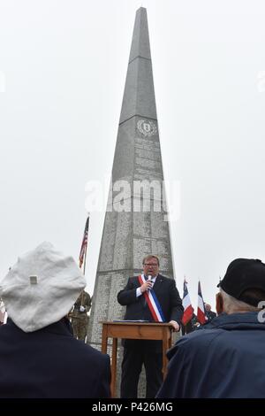 COLLEVILLE-SUR-MER, Frankreich - Soldaten, Veteranen und Zivilisten um 1 Infanterie Division Denkmal für eine Gedenkveranstaltung zu Ehren der Männer von der "Big Red One", die während der Invasion in der Normandie kämpfte eingekreist. Die über 30 m hohe Obelisk mit den Namen der einzelnen Menschen in Aktion getötet eingraviert. (U.S. Armee Foto von Sgt. 1. Klasse Crista Mary Mack) Stockfoto