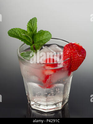 Infundiert detox Wasser mit Erdbeere und Minze. Eis kalten Sommer Cocktail oder Limonade aus Glas. Stockfoto