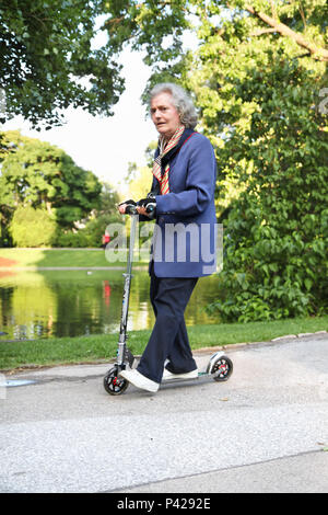 Wien; Österreich - Mai 23: Großmutter reiten im Park auf Motorroller, 23. Mai 2010 in Wien, Österreich Stockfoto