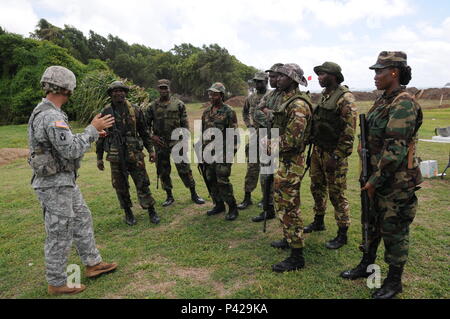 Der Soldat mit dem Florida Army National Guard beauftragt Mitglieder der Grenada besonderen Service Informationen zum Bereich Sicherheit bei M16 live Fire Training in der Nähe von Perlen Flughafen, 7. Juni als Teil der Masse Training Schiene von Tradewinds 2016. Tradewinds 2016 ist eine gemeinsame kombinierte Übung in Verbindung mit Partnerstaaten durchgeführt, um die kollektiven Fähigkeiten der Streitkräfte und constabularies grenzüberschreitende organisierte Kriminalität entgegenzuwirken und Humanitäre/Katastrophenhilfe Operationen durchzuführen, zu verbessern. Stockfoto