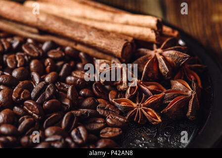 Kaffee Bohnen mit Zimtstangen und Chinesischer Sternanis auf der Metallplatte. Stockfoto