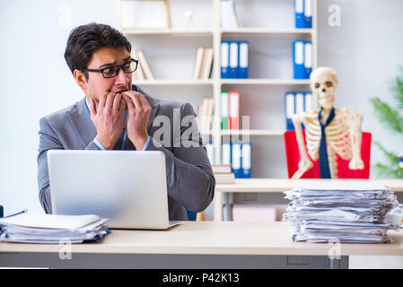 Unternehmer arbeiten mit Skelett im Büro Stockfoto