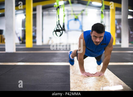 Junge starke Mann pushups tun bei Cross Fitness Gym Stockfoto