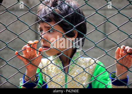 Kulgam, Indien. 19 Juni, 2018. Ein kleines Mädchen Uhren das Begräbnis der Zivilen Aijaz Ahmad Bhat außerhalb der Umzäunung an Nowpora, Aijaz einen Zivilisten, die durch die indische Armee in der Nähe von seinem Haus in Nowpora im Süden von Kaschmir Kulgam rund 60 Kilometer von der Hauptstadt Srinagar getötet wurde. Credit: Muneeb ul-Islam/Pacific Press/Alamy leben Nachrichten Stockfoto