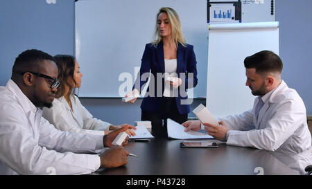 Junge lächelnde Frau Doktor präsentiert ein weißes Feld ohne Pillen Stockfoto