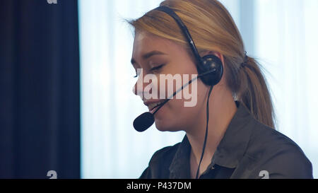 Weibliche customer support Operator mit Headset sprechen und lächelnd Stockfoto