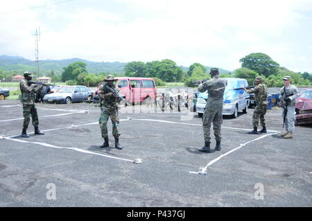 Sgt. 1. Klasse Curt Kinker, der Florida National Guard, Uhren als Mitglieder der Grenada spezielle Service Unit verhalten Zimmer clearing Übungen zu Perlen Flughafen in Grenada, 7. Juni 2016. Die übung war Teil der Tradewinds 2016. Tradewinds ist eine multi-nationale maritime Sicherheit und Katastrophenschutz Übung. Phase I wird von Grenada ab 4. Juni bis 14. Juni organisiert wird. Stockfoto