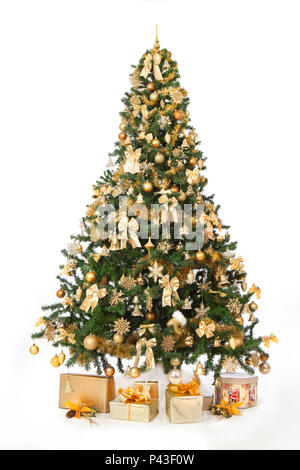 Reich geschmückten Weihnachtsbaum mit goldenen Ornamenten, mit einem weißen Hintergrund und eine Geschenke für ein neues Jahr isoliert. Vertikale studio schießen. Stockfoto