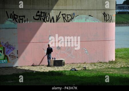 Graffiti Sprayer bei der Arbeit auf der Brücke Pier am 24.08.2014 in Düsseldorf - Deutschland. | Verwendung weltweit Stockfoto