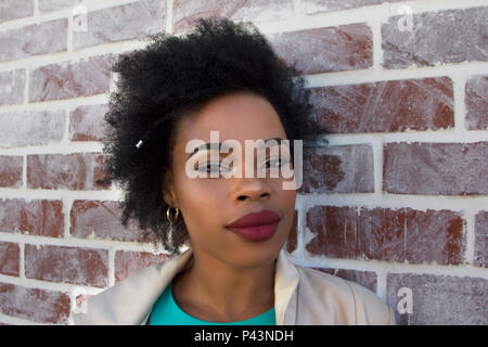 Eine afrikanische Frau Modell stellt gegen eine weiße Wand gewaschen Stockfoto