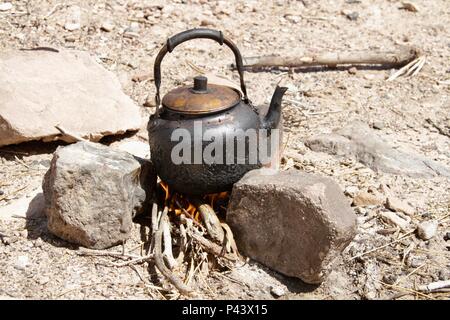 Zerschlagene Wasserkocher auf offenem Feuer, in Jordanien Wüste Stockfoto