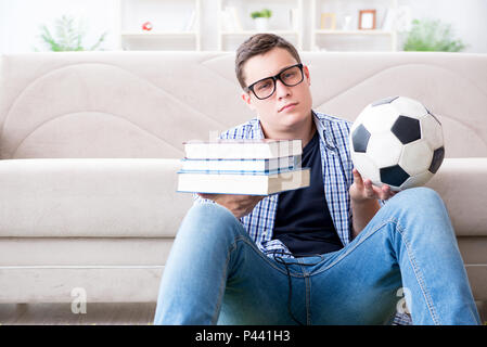 Junge Studenten, die versuchen, zu studieren und spielen Fußball Stockfoto