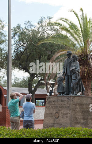 Touristen sehen die Einwanderer-Statue steht in den öffentlichen Centennial Park im alten Teil von Ybor City, Florida. Stockfoto