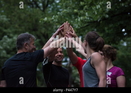 Gruppe von gesunden Läufer, fünf auf einander beim Erfolg feiern nach dem Training. Stockfoto