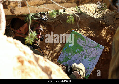 Ein Norwegischer Soldat in eine defensive Position Punkte zu einer Position auf einer Karte in einem simulierten Gefecht Demonstration für Sehr geehrte Besucher von Soldaten aus dem Vereinigten Königreich, Norwegen und Polen während Sabre Streik 16., 13. Juni an Adazi Militärbasis, Lettland. Sabre Streik ist eine gemeinsame Übung der US-Armee Europa led-Spanning von Mai 27 bis Juni 22 in Standorten in Estland, Lettland und Litauen, mit 13 teilnehmenden Nationen. Teilnehmenden Kräfte in Lettland gehören Service Mitglieder von F Troop, 2nd Squadron und B Batterie, Field Artillery Squadron, 2.Kavallerie Stockfoto