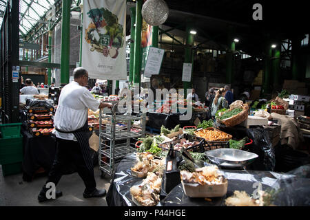 Rüben Obst und Gemüse Verkäufer bei Borough Market in London, England, Vereinigtes Königreich. Borough Market ist ein Retail Food Markt und Bauernmarkt in Southwark. Es ist eines der ältesten und größten Lebensmittelmärkte in London, mit einem Markt auf der Website zurückgehend bis mindestens ins 12. Jahrhundert. Ein Bauernmarkt ist eine physikalische Retail Markt bestimmt sind Lebensmittel, die direkt von den Bauern für die Verbraucher verkaufen. Die Landwirte Märkte können drinnen oder draussen zu sein und bestehen in der Regel aus Ständen, Tabellen oder steht, wo die Bauern verkaufen Obst, Gemüse, Fleisch, Käse, und manchmal auch Lebensmittel und Getränke. Stockfoto