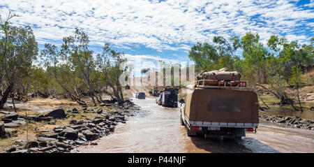 Gibb Herausforderung 2018 ein Konvoi von 4 WD-Support Fahrzeuge durch einen Fluss überqueren der Gibb River Road Kimberley Australien fahren Stockfoto