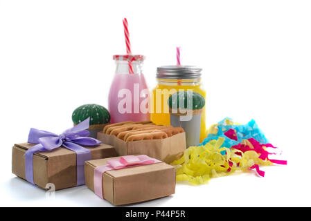 Dekorative Komposition festliche exotischen Cocktail auf weißem Hintergrund mit Konfetti Geschenk Satinband. Natürliche Drink in ein Glas mug Stockfoto