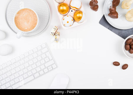 Frohe Ostern. Stilvolles Briefpapier Hintergrund mit Schokolade Eier. gold und weiße Eier und Zubehör auf weißem Hintergrund. Tabelle verzieren für Urlaub Stockfoto