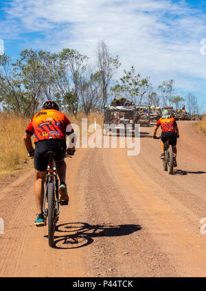 Gibb Herausforderung 2018 Radfahrer in Jersey und Bib fatbike Reiten und Mountainbike Konvoi 4WD Fahrzeuge auf unbefestigten Straße der Gibb River Road Kimberley Australien Stockfoto