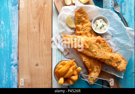 Traditionelle britische gebratener Fisch in Teig mit Chips in einem Korb Stockfoto