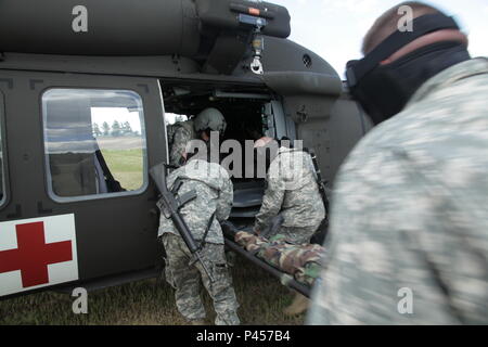 Us-Armee Soldaten aus der 108 multifunktionale Medizinische Bataillon, Oklahoma Army National Guard, Verkehr einen Unfall ein HH-60 M Medevac Hubschrauber während eines lebensrettenden Maßnahmen Ausbildung Lane West Camp Rapid während der Goldenen Coyote Übung, Rapid City, S.D., 14. Juni 2016. Die goldenen Coyote Übung ist eine dreiphasige, Szenario-driven Übung in den Black Hills von South Dakota und Wyoming, mit dem Kommandanten auf der Mission wesentliche Anforderungen der Aufgabe, Krieger Aufgaben und Übungen zu konzentrieren. (U.S. Armee Foto von Sgt. 1. Klasse Horace Murray/Freigegeben) Stockfoto