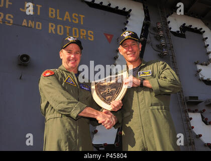 20160614-N-TR 801-052 NORFOLK (14. Juni 2016) Vice Adm. Michael Schuster, Links, Commander, Naval Air Forces, präsentiert eine Schlacht Wirksamkeit Award Plakette zu Kapitän Timothy C. Kuehhas, der kommandierende Offizier der Flugzeugträger USS George Washington (CVN 73) während einer alle Hände auf den Flight Deck zu nennen. Die Schlacht "E" wird jährlich an U.S. Navy Schiffe, U-Boote, Luftfahrt und anderen Einheiten für die Bereitschaft der Kriegszeit Aufgaben vergeben. (U.S. Marine Foto von Mass Communication Specialist Seaman Michael E. Wiese/Freigegeben) Stockfoto