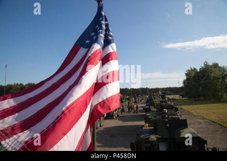 Eine US-Flagge Wellen aus einem Stryker Armored Fighting Vehicle als 4. Staffel, 2. Kavallerie Regiment Soldaten bereiten Bewegung während eines Dragoon Ride II Konvoi von Powidz nach Bydgoszcz, Polen, 5. Juni 2016 zu starten. Dragoner reiten II, ist die 2.200 Kilometer lange Konvoi nach Estland in Vorbereitung auf die Übung Sabre Streik 2016, ein US Army Europe - LED-kooperative Ausbildung Übung entwickelt gemeinsame Interoperabilität multinationaler Blindbewerbungen zu unterstützen, zu verbessern. (U.S. Armee Foto: Staff Sgt. Ricardo HernandezArocho/Freigegeben) Stockfoto