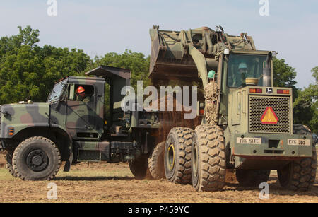 Marines mit Firma C, 6. Engineer Support Battalion, 4. Marine Logistics Group, Marine Forces Reserve klar Schmutz von einer Baustelle Parkplatz mit Hilfe von Kommandos mit 131 Commando Squadron Royal Engineers, britische Armee, während des Trainings rot Dolch am Fort Indiantown Gap, Penn, 11. Juni 2016. Als Teil der Übung die Marines und britischen Commandos an verschiedener Renovierung und Bau Projekte rund um die Kaserne gearbeitet. Übung rot Dolch ist eine bilaterale Trainingsübung, die Marines Gelegenheit gibt, auszutauschen, Taktiken, Techniken und Verfahren sowie die Arbeit aufbauen Stockfoto