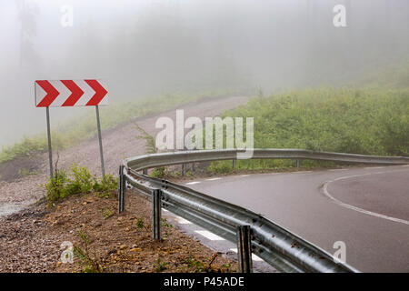 Mountain Pass Road mit kurvigen Straße Zeichen und Bäume im Nebel Landschaft - Rumänien Stockfoto