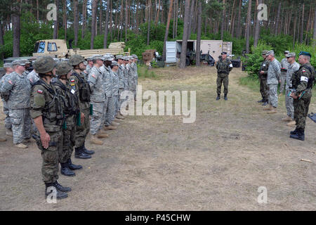 Soldaten des 5.BATAILLON, 113 Field Artillery Regiment (High Mobility Artillery Rocket System), North Carolina National Guard, und polnische Soldaten stehen in der Ausbildung der Polnischen Armee Oberst Slawomir Owczarek, der Leiter der Field Artillery für die polnischen Streitkräfte, spricht mit dem gemischten Gruppe über ihre Professionalität während der Übung Anakonda16 am Drawsko Pomorski, Polen, 16. Juni 2016. Ein 16 ist eines der führenden multinationalen Ausbildung Veranstaltungen U.S. Army Europe. Es ist eine polnische Nationale Bewegung, die versucht, zu trainieren, Übung, und Integrieren der polnischen nationalen Befehl und Kraft Struktur Stockfoto