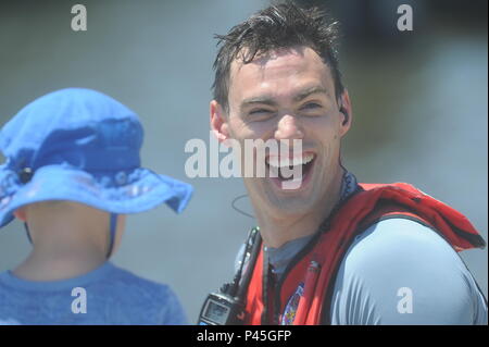 Foto: PA 3 Nathan Cox | Petty Officer 2nd class Stephen Scheren lacht Nach dem Besuch mit seiner Familie nach einer Rettungsschwimmerin Demonstration am Hafen Fest in Norfolk, VA, Juni 10, 2016, um 14:00 Uhr. Die Küstenwache demonstriert das Springen von einem MH-60 Hubschrauber und Schwimmen ein Dummy im Wasser zu retten Das Verfahren während eines tatsächlichen rescue Situation zu zeigen. Coast Guard Foto von Petty Officer 3. Klasse Nathan Cox. Stockfoto