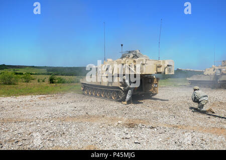 Mississippi Army National Guard Soldaten mit Batterie B, 2d-Bataillon, 114 Field Artillery Regiment, 155 gepanzerte Brigade Combat Team, sehen für die Auswirkungen nach dem Feuern während einer M106 Paladin direkten Brand in Fort Hood, Texas, 16. Juni 2016. (Mississippi National Guard Foto: Staff Sgt. Scott Tynes, 102 d Public Affairs Ablösung/Freigegeben) Stockfoto