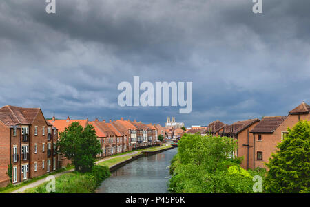 Sturmwolken über der alten Münster, Stadt Häuser, und die Beck im Frühjahr, Beverley, Yorkshire, UK. Stockfoto