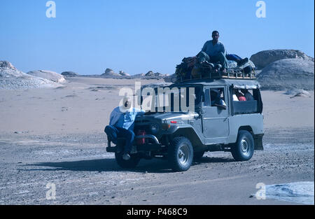 Eine touristische Jeep in der ägyptischen Wüste mit dem Reiseleiter saß auf dem vorderen Stoßfänger Stockfoto