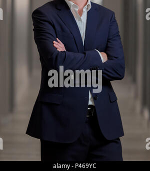 7/8 Kopf Mann in einem smart Anzug mit verschränkten Armen Stockfoto