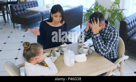 Familie im Cafe Streit. Mutter ist sehr nervös Schelte an Tochter und Ehemann. Stockfoto