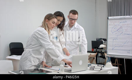 Team von Ärzten, die auf Notebook- und Analyse von xray in medizinischen Büro Stockfoto